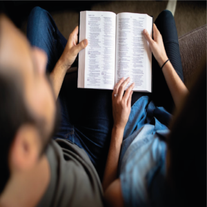 casal olhando para biblia