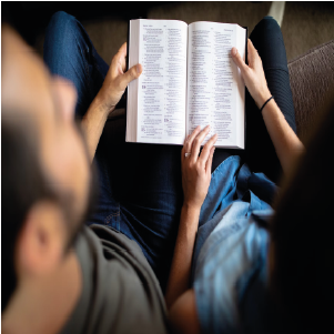 casal olhando para biblia