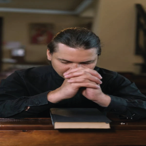 homem orando com uma bíblia